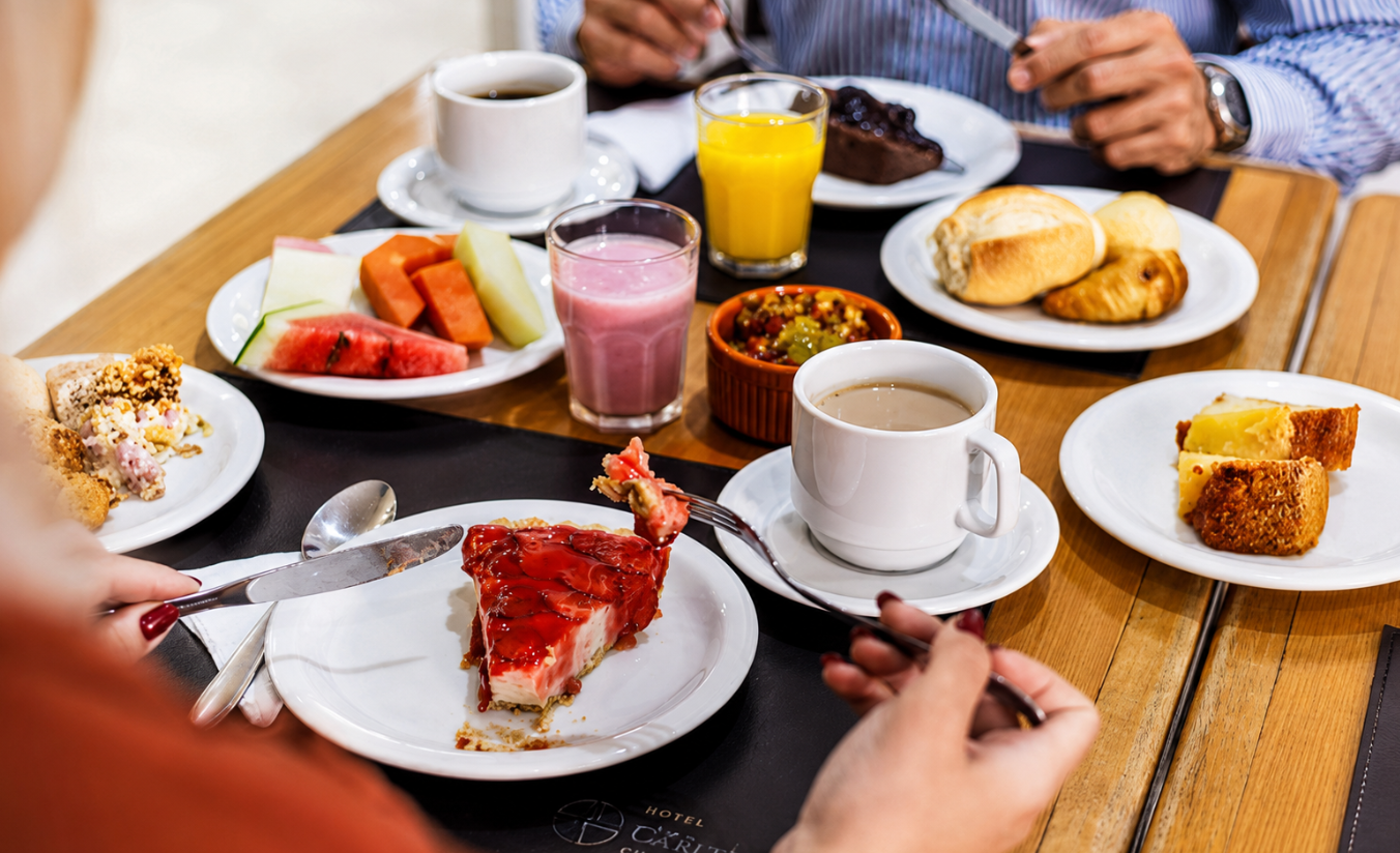 Mesa de café da manhã servida no Hotel Dan Inn Curitiba, com frutas, pães e sucos